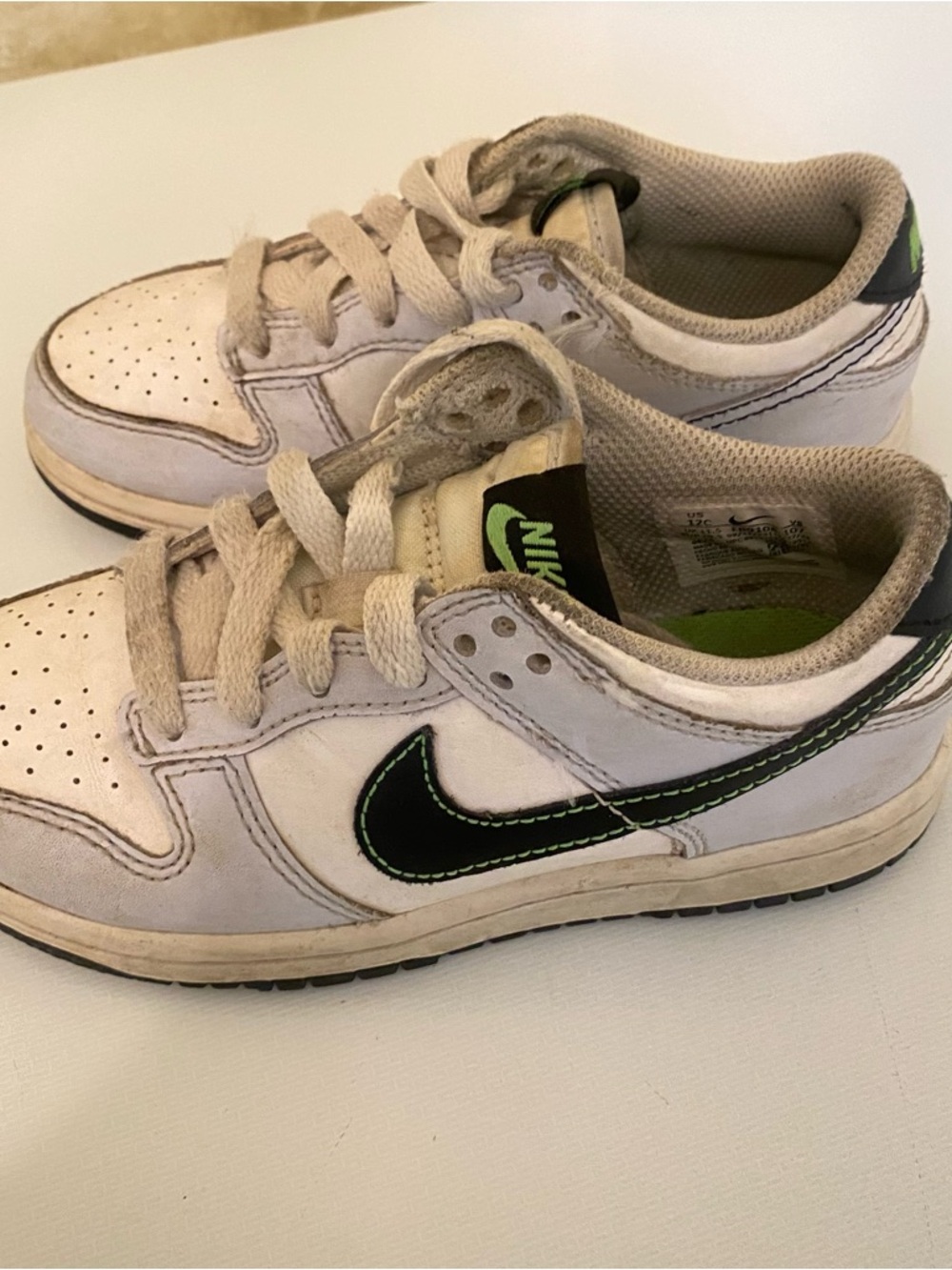 Nike Kids White Sneakers with Black Swoosh and Green Accent